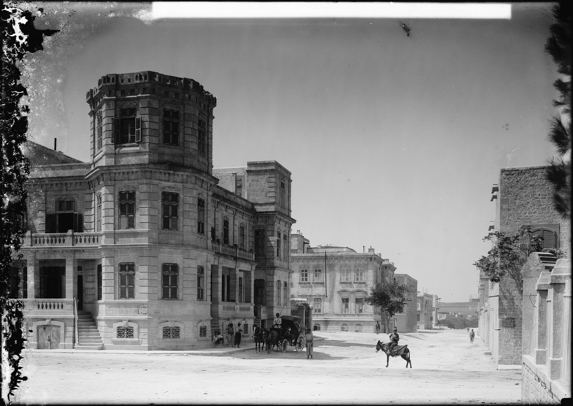 An early twentieth-century street in the new quarters of Aleppo, tram lines running down the middle.