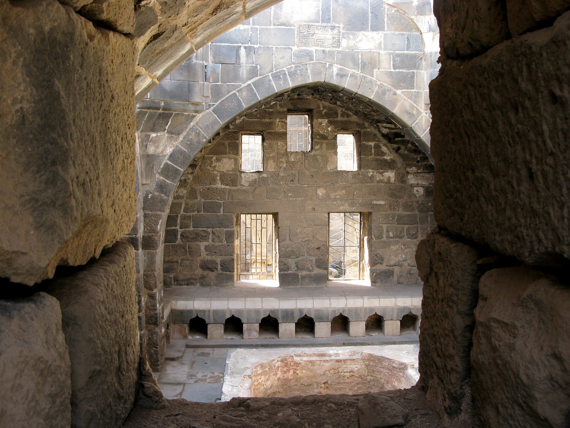 The basalt citadel at Bosra, its dark stone walls rising in tiers.
