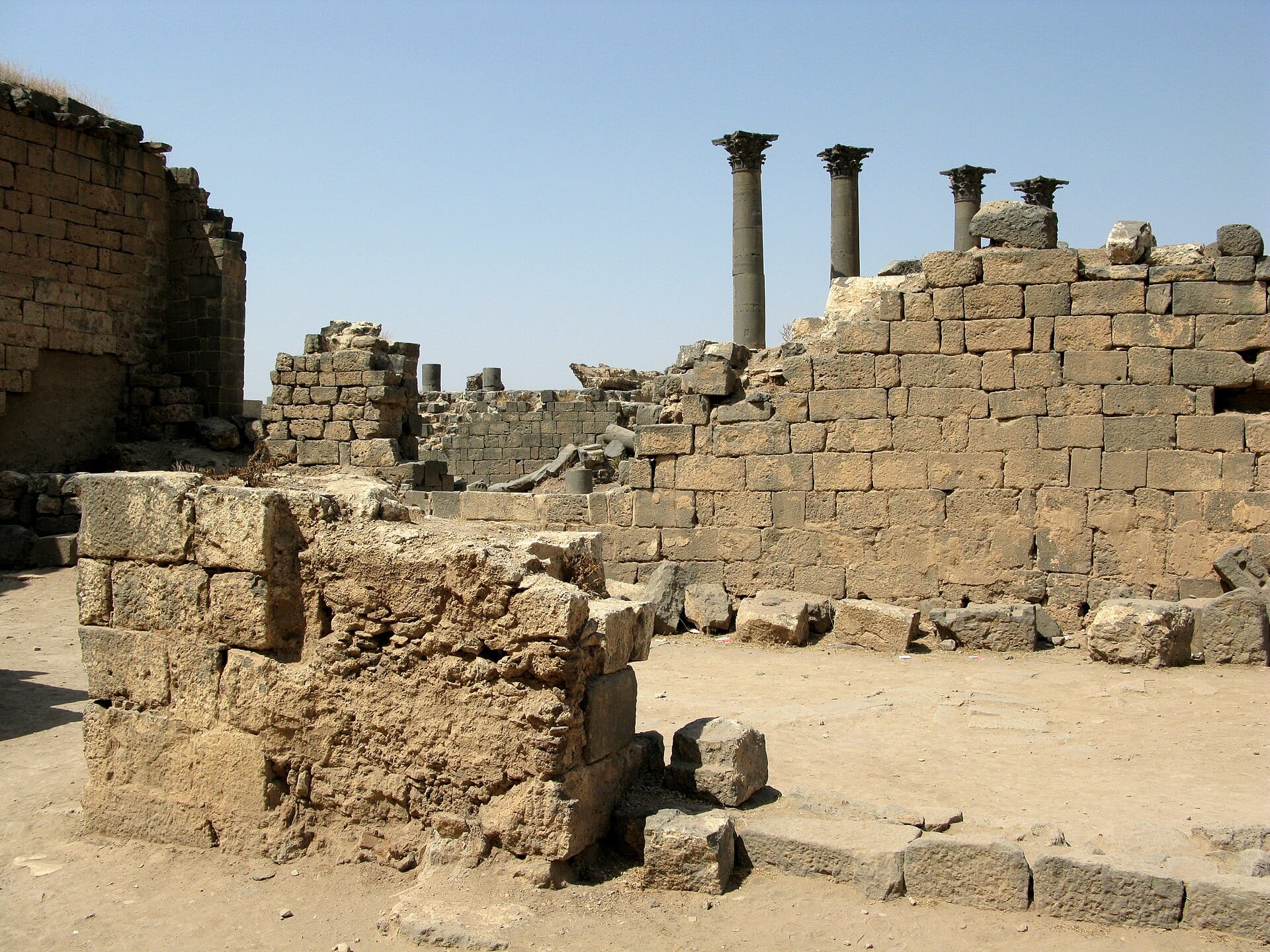 Black basalt ruins and standing columns in the ancient city of Bosra, in Daraa governorate.