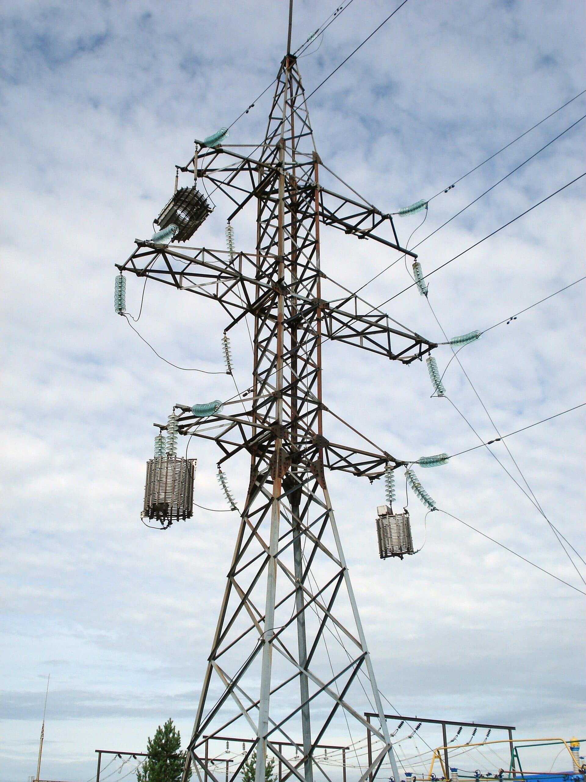 The upper section of a transmission tower, with a fibre-optic ground wire running above the phase conductors.